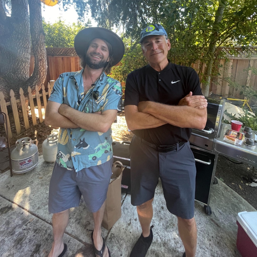 Two friends posing by the grill at a backyard show