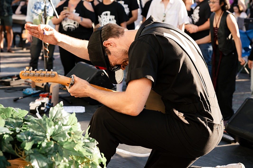 A guitarist bowing mid-performance