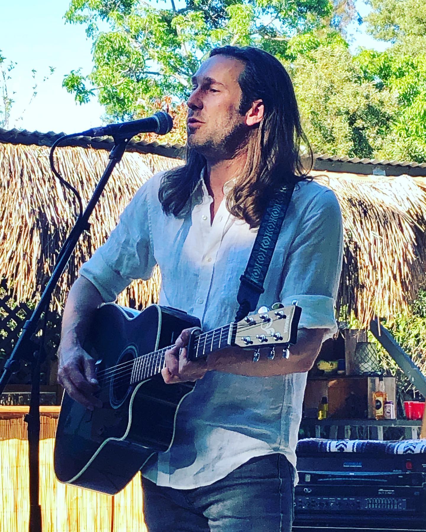 A singer performing an acoustic set under string lights