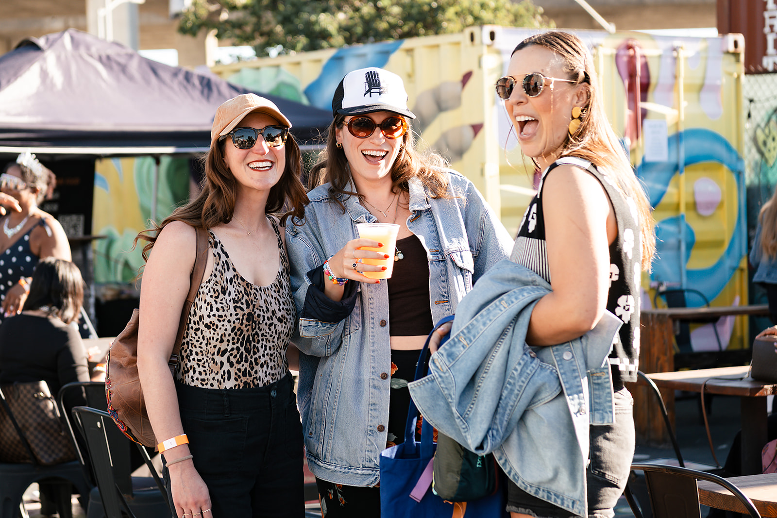 Three friends laughing together at the festival