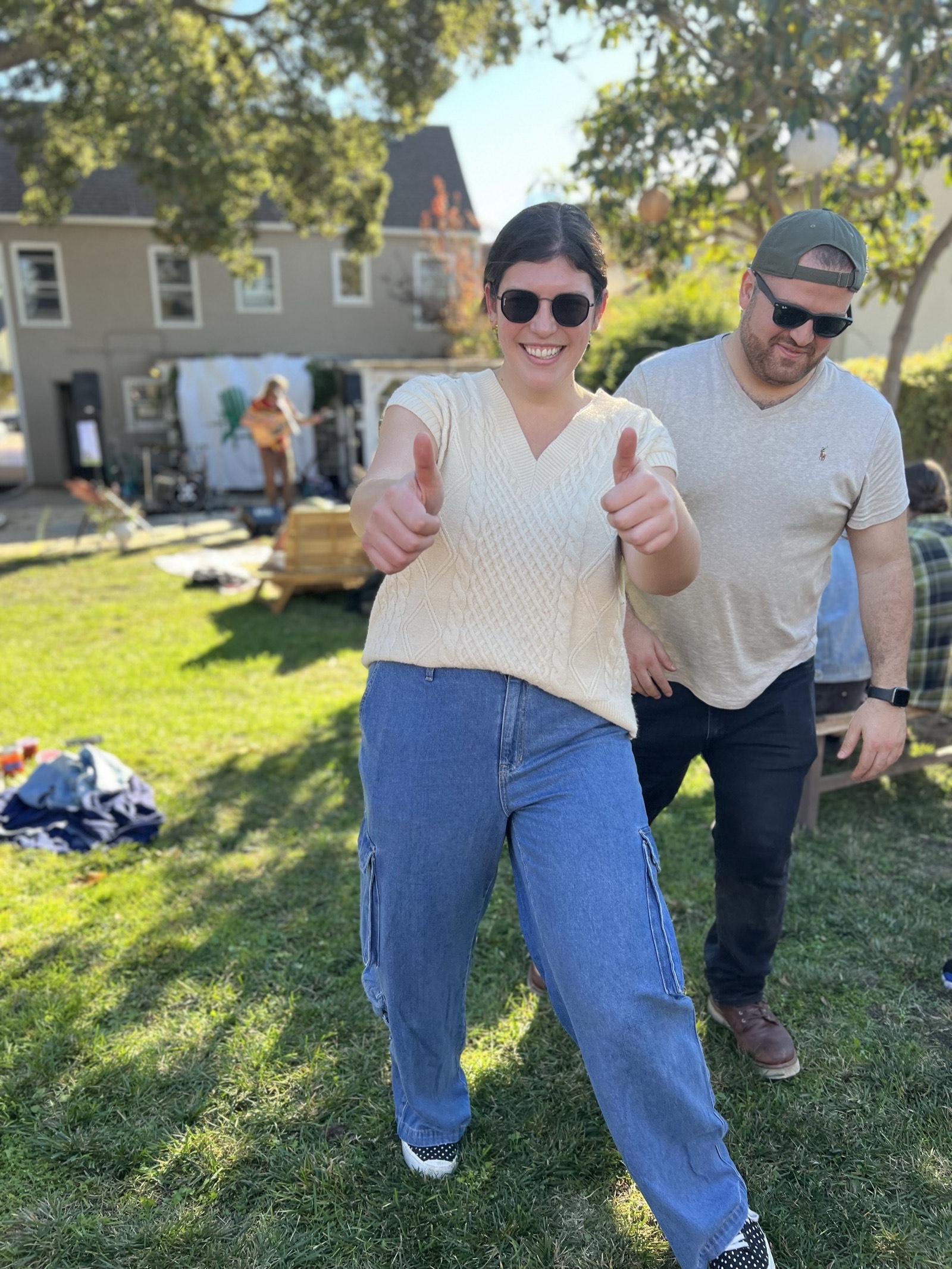 Two friends giving a thumbs up on the lawn